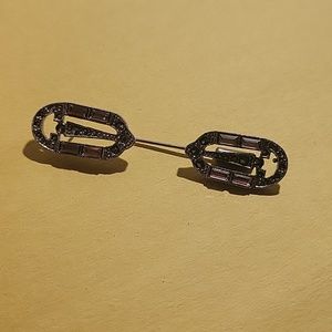 Silver with purple stone brooch.